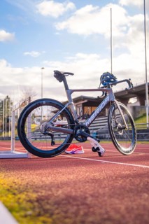 Grey racing bike on a red track with sunny sky in the background, triathlon bike, Calw, Germany