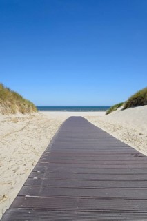 Boardwalk leads through the dunes to the extensive sandy beach, blue sky, North Sea, Juist, East