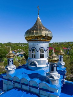 Detailed view of a golden dome on a blue roof under a blue sky, aerial view, Orthodox church,