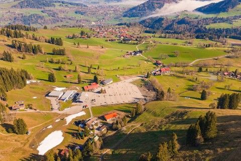 Aerial view of a village in a green, hilly landscape with wooded areas, Allgäu, Bavaria, Germany