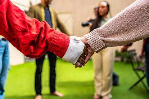 Group of diverse people holding hands in a circle, finding unity and support in a community,