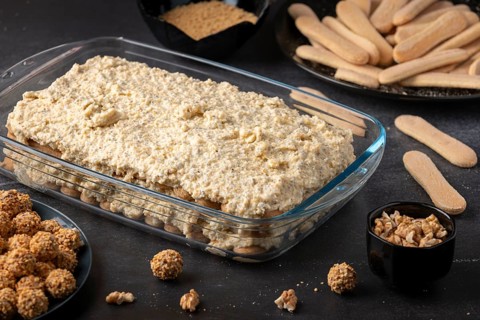 Ingredients for tiramisu, sponge cake and curd cream layered in glass form