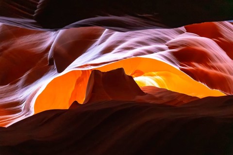Antelope canyon slot canyon walls with flowing sandstone curves and soft light filtering narrow