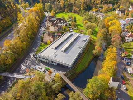 Industrial building nestled in autumnal nature near the river and neighboring residential