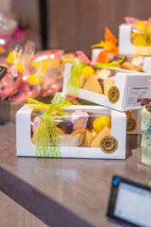 Gift boxes with colorful handmade cookies, decorated with yellow bows, presented on a table, Café