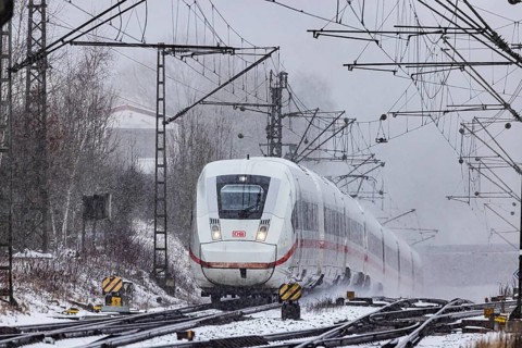ICE traveling through a winter landscape in snowfall. A train on the line in the Deutsche Bahn