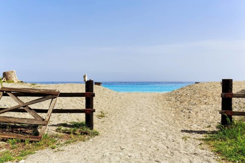 Beach access, sandy path with fence, single lost shoe, turquoise Mediterranean, Leonidi, Leonidio,