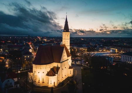 Siauliai, Lithuania - 12th november, 2024: aerial fly over view illuminated Roman catholic Church