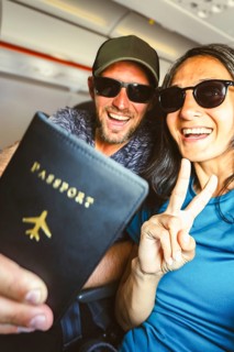 Happy young tourist couple taking selfie inside airplane - Cheerful couple on summer vacation -