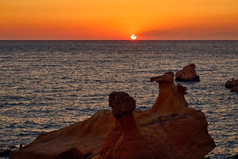 Red sunset over calm sea and distinctive rock formations, Aspragremna, White Cliffs, Mavorspilia
