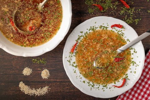 Decorated soup plate next to a smiling quinoa face on rustic table