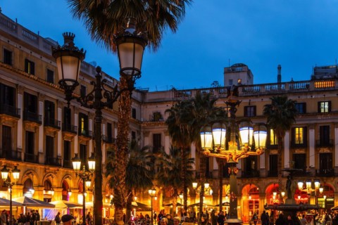 Nightlife at Plaça Reial, lanterns by Gaudi in the historic centre of Barcelona, Spain