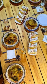 Delicious traditional moroccan meal with couscous, chicken tajine, assorted vegetables, and sweet