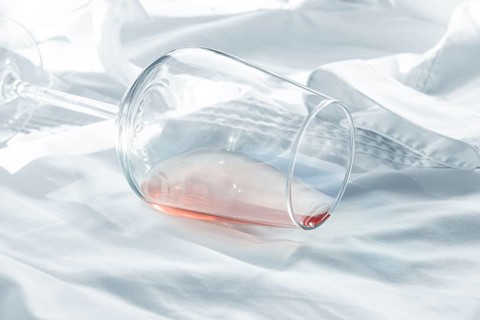 Glass, with pink wine, spilled on a white shirt, close-up, selective focus, no people, concept, top