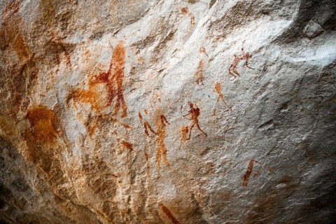 Prehistoric hunter with bow, ancient rock carving of the San, indigenous people of South Africa,