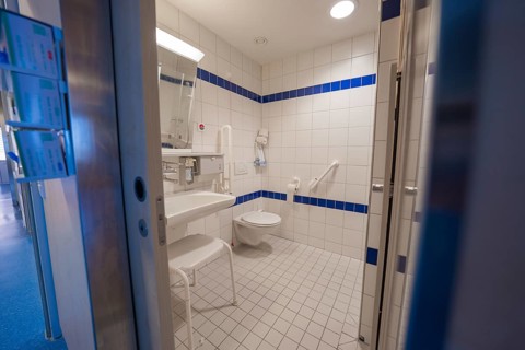 A bathroom suitable for the disabled with white tiles and blue accents in the hospital, Nagold