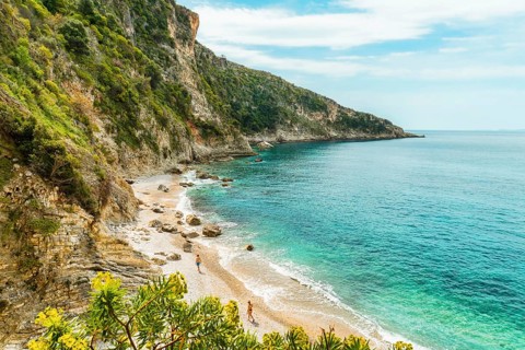 Viewpoint panorama couple enjoy walk isolated on Filikuri beach in spring. Clear turquoise Ionian
