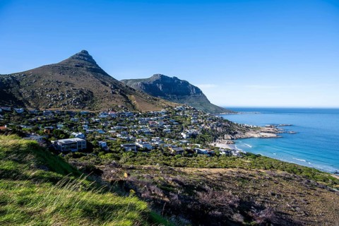 Sea Point and Lions Head, homes and mountains along a picturesque coastal bay with blue water,