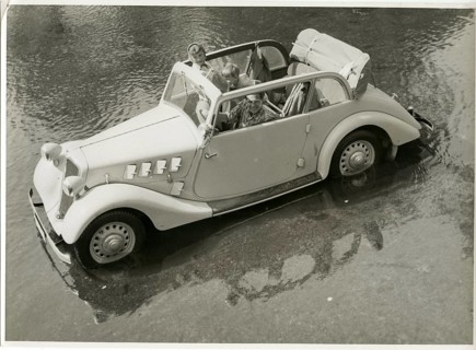 Adler, vintage car, OKW, in water, commercial shot, A convertible with occupants standing in