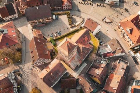 Aerial view of a historic old town with half-timbered houses and a centrally located church,