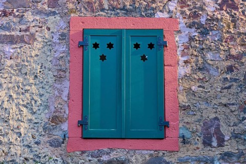 Green shutters with star patterns on a stone wall, Erbach, Odenwald, South Hesse, Hesse, Germany