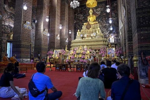 Praying Buddhists at Wat Pho, Temple of the Reclining Buddha, Bangkok, Thailand