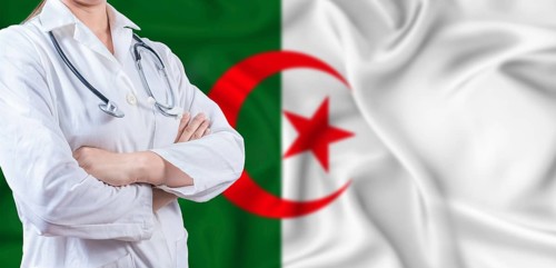 Doctor with crossed arms on Algeria flag. Algerian health and care concept. Female doctor on