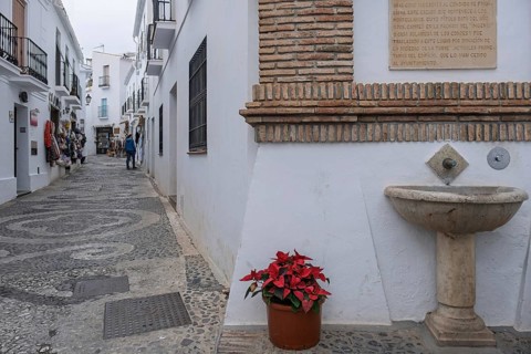 Alley and fountain in the white village of Frigiliana, Malaga province, Andalucia, Spain