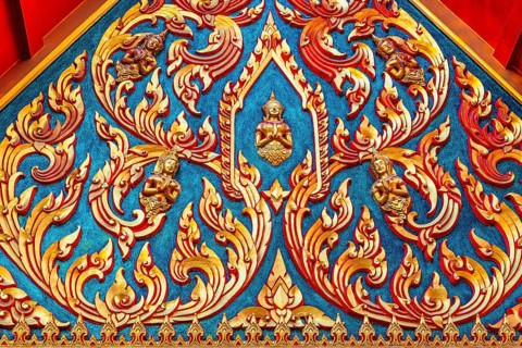 Colourful traditional temple ornaments with filigree gold ornaments on a blue background, Koh Kret