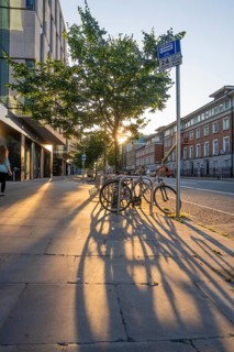 Bikes cast long shadows on a quiet urban street in golden evening light, Dublin, Ireland