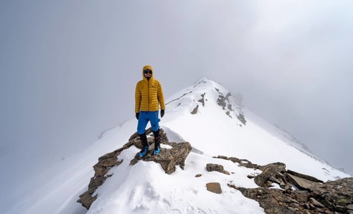 Ski tourer on the cloudy summit of Kesch Pitschen, Bündner Haute Route ski tour, Albula Alps,