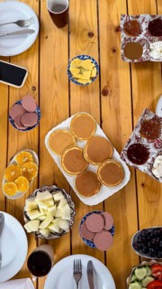 Wooden table filled with a diverse and healthy morning meal. Featuring golden pancakes. An