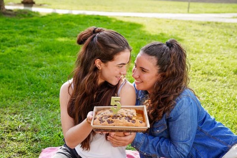 A young cheerful romantic LGBTQ+ couple enjoying a special moment in the park while sharing a