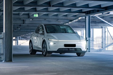 White electric car in a modern garage with steel beams, Tesla, New Model Y Juniper, Germany