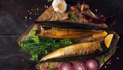 Smoked mackerel, top view, with spices, on a wooden table, no people, selective focus