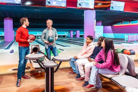Group of multi ethnic friends enjoying a bowling game together at the entertainment center