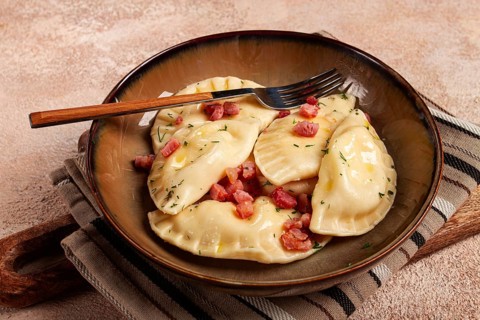 Dumplings, with fried prosciutto, a traditional dish of Polish cuisine, dumplings, top view,