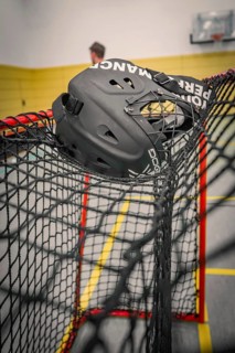 Black floorball helmet caught in a net in a sports hall, Foolball, Calw, Germany