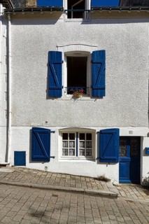 White painted house with blue shutters and blue door on the hillside, Upper Town, Auray, Morbihan,