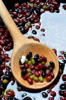 Dried beans placed in water to soak, wooden spoon