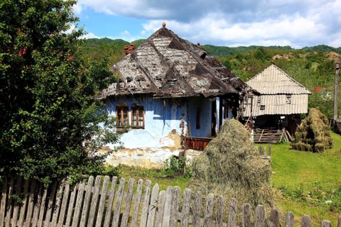 Traditional Romanian farmhouse that is in a dilapidated or abandoned state. The eye-catching light