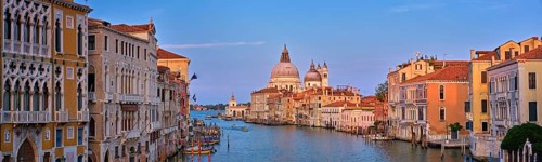 Panorama of Venice Grand Canal with boats and Santa Maria della Salute church on sunset from Ponte