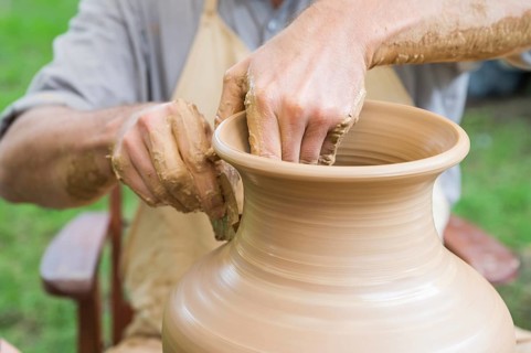 Hands of a man making a clay vase on a potter's wheel in Boleslawiec, Poland