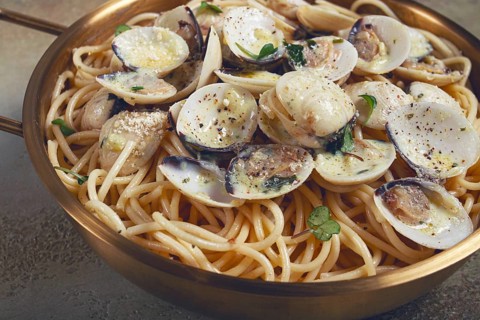 Spaghetti with vongole clams, in cream sauce, carbonara, in a brass pan, homemade, top view, no