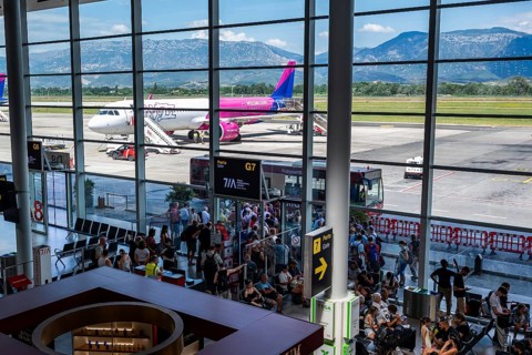 TIRANA, ALBANIA - JULY 3, 2026: Busy airport terminal with passengers waiting for departure,