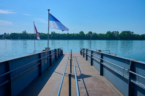 Dock on the river, flags fly in the wind under a clear sky, Rhine, Eltville am Rhein, Rheingau,