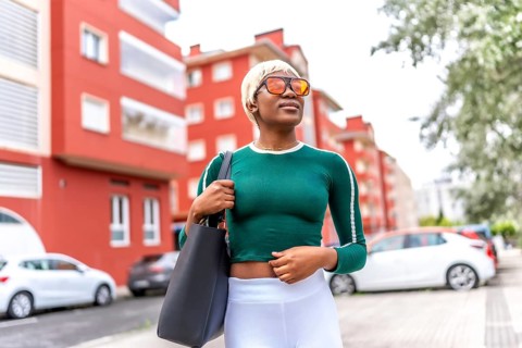 Frontal portrait of a beauty urban blonde african woman with handbag strolling in the city