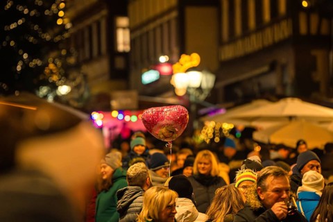 Lively night market with lots of people and a heart-shaped balloon above the crowd, Christmas