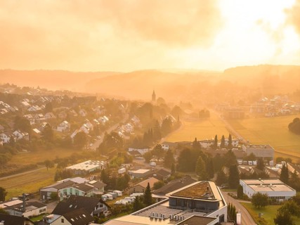 A village at dawn with wafts of mist, illuminated by the rising sun, Gechingen, Black Forest,