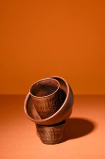 Composition with clay bowls on orange background with hard shadow